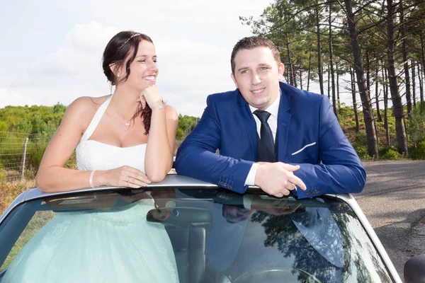 In love bride and groom on their cabriolet wedding car