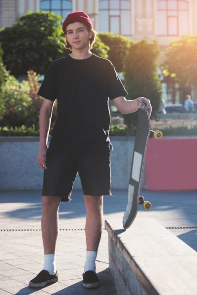 Young man holding skateboard.