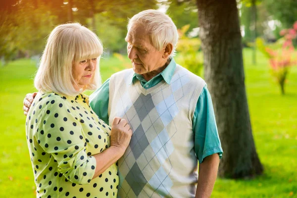 Sad elderly couple outdoor.