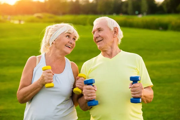 Smiling couple with dumbbells.