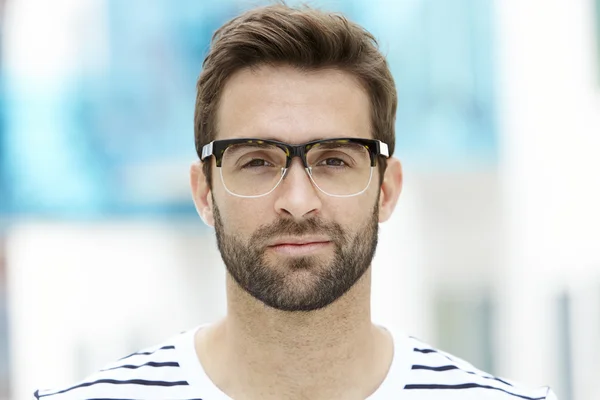 Man with stubble wearing spectacles