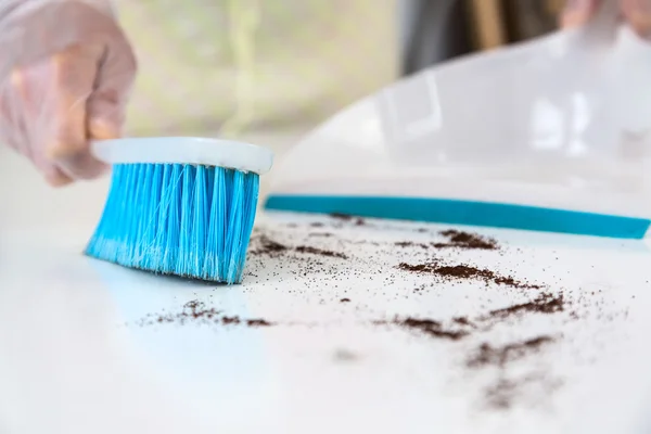 Person making household Cleaning with Brush and Shovel