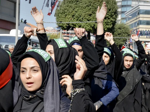 Shiite Muslim women hold up their chained hands