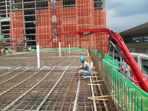 A group of construction workers pouring concrete into floor slab form work