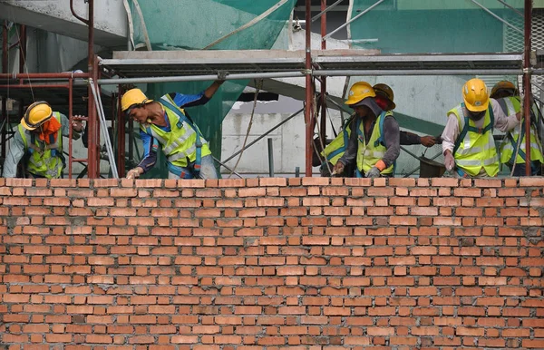 Construction workers laying bricks at construction site