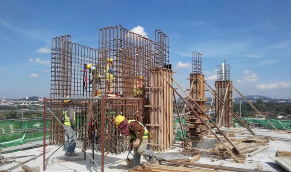 Group of construction workers fabricating steel reinforcement bar