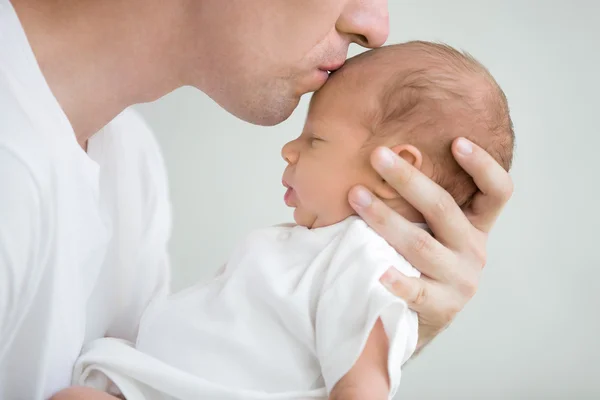 Portrait of man kissing his baby