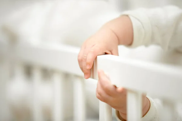 Infant tiny hands in the crib