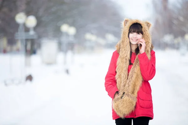 Young woman talking on phone outdoors in wintertime