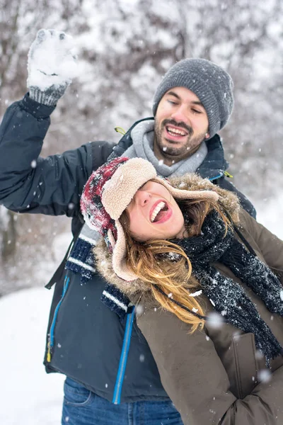 Couple having fun in snow covered park