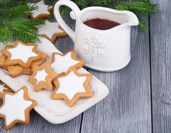 Christmas gingersnap in the form of asterisks and hot chocolate on a gray wooden background. A Christmas background with the place for the text.