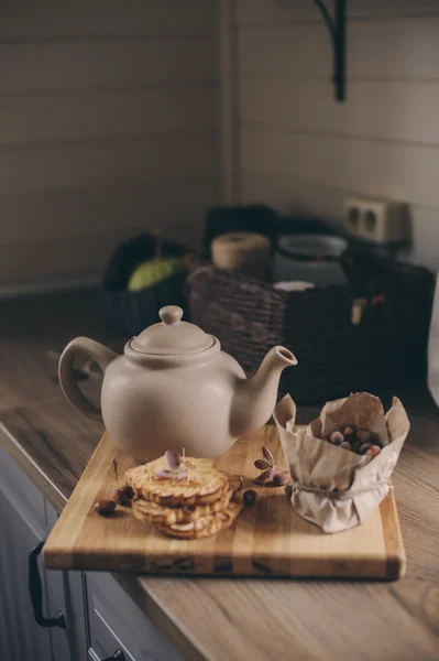 Tea pot and cookies in rustic grey kitchen interior. Slow living in country house concept. Cozy morning at home