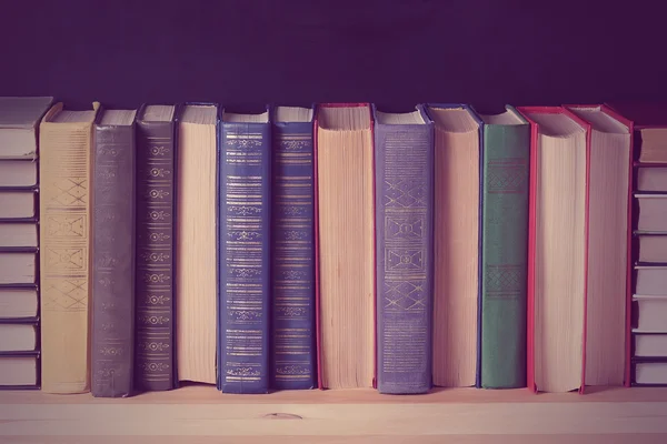 Books on the shelf on a black background.