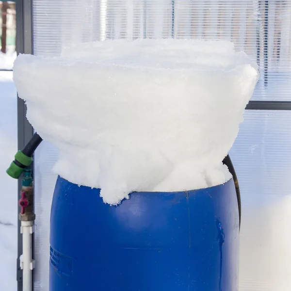 Plastic barrels filled with snow