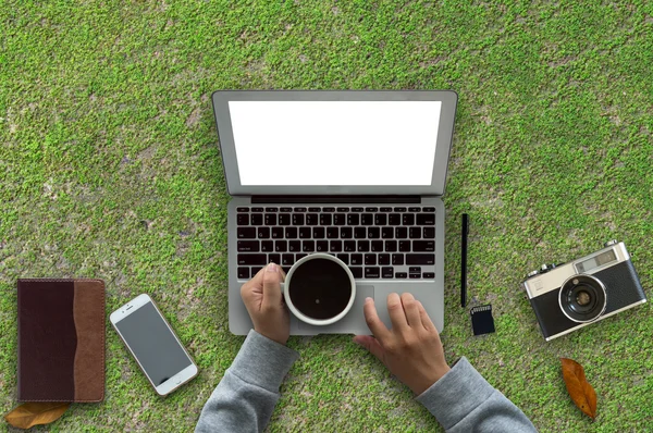 Business office with computer,note book,phone,camera and coffee cup in green background.copy space.