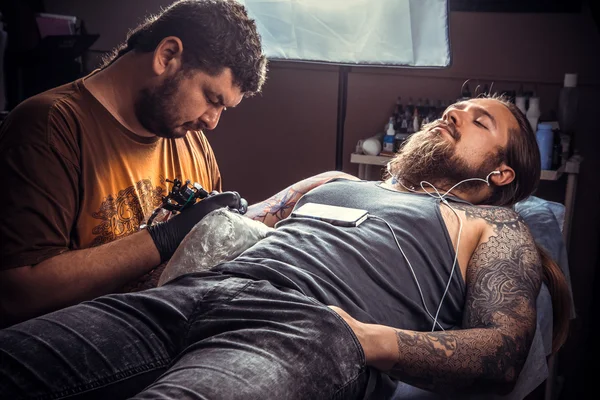 Tattooer makes cool tattoo in tattoo studio