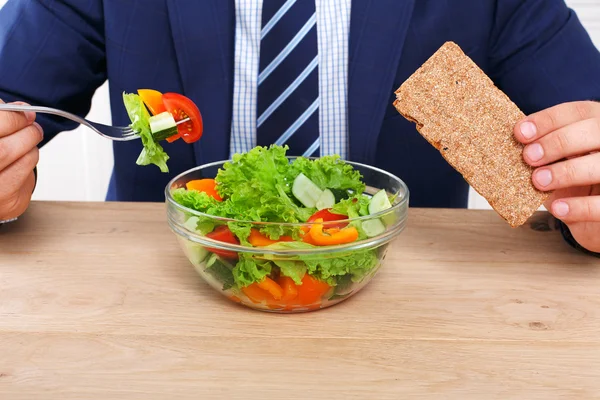 Unrecognizable man has healthy business lunch in modern office
