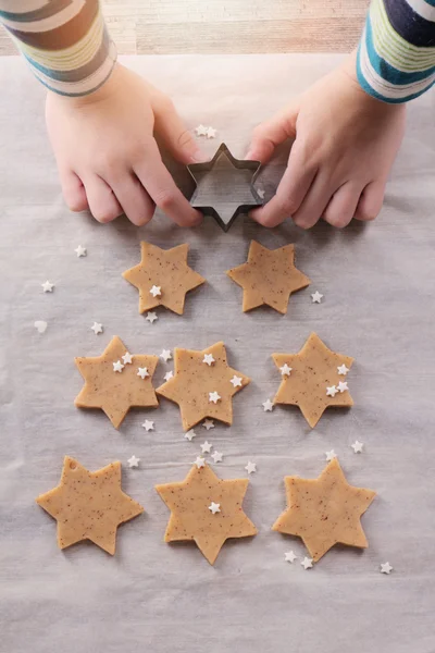 Kid putting star on top of the Christmas tree make from gingerbread cookies. New year, Happy Family lifestyle concept background. Baking with children