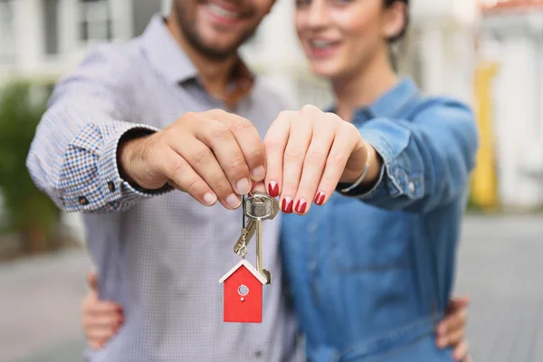 Young couple holding up keys