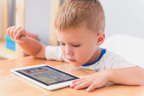 Cute little boy using digital tablet