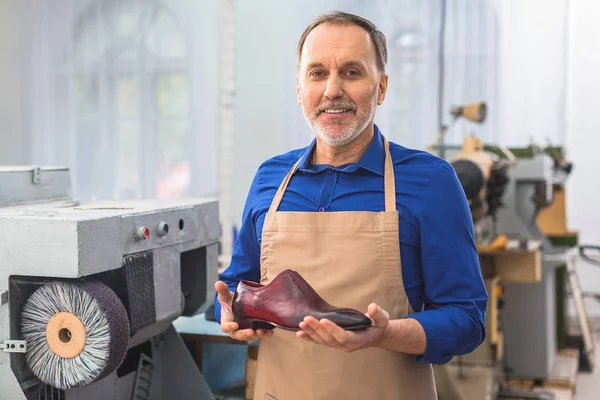 Cobbler holding a brand new footwear