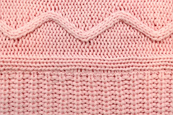 Pink knitted texture with geometric waves.