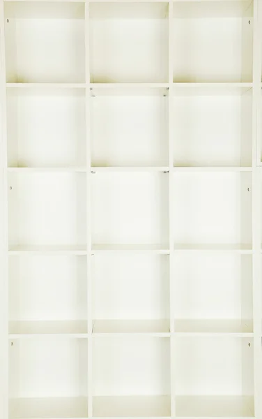 Empty shelves in white wooden rack