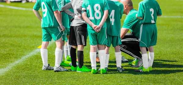 Soccer coach giving young football team instructions. Youth soccer team before final game. Football; soccer match for children. Football soccer game. Soccer football background. Motivational strategy talk for sports team