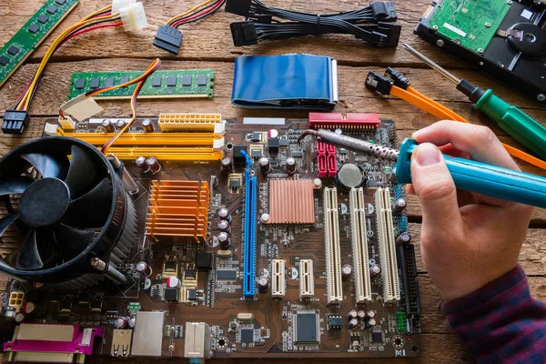Man soldering computer hardware, repair