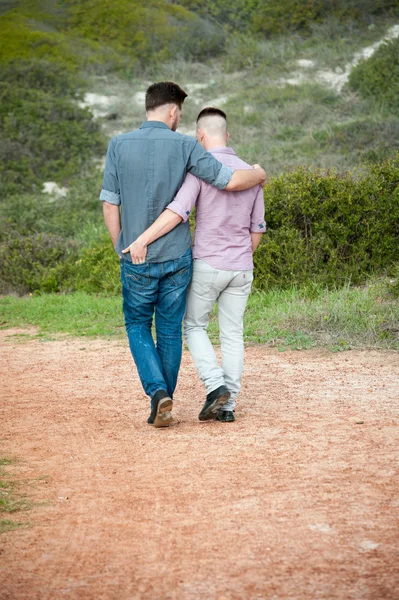 Gay men walk along a gravel path