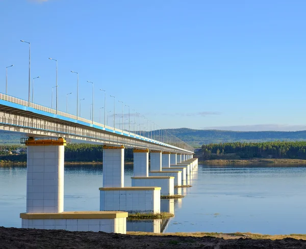 The bridge across the Angara River. Beautiful white yellow bridge over the River.