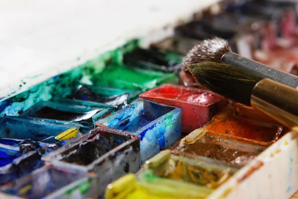 Artists brushes and watercolour paints on palette