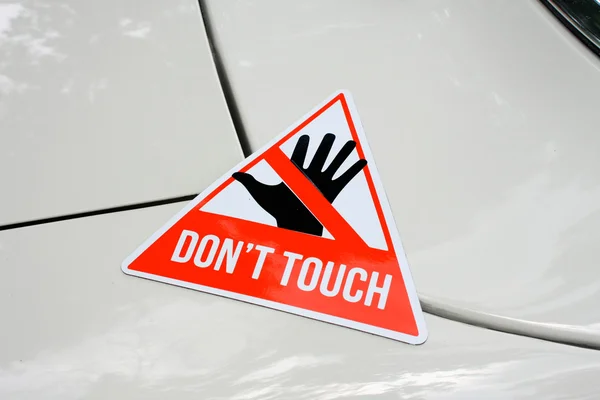 Warning sticker with text Don't touch on some car