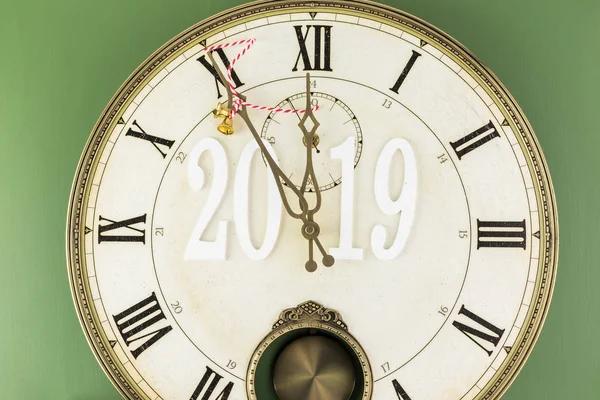 Arriving 2019. Clock shows five minutes till  New Year.