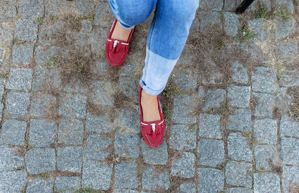 Womens foot close up in jeans and red loafers