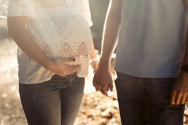 Pregnant woman and man holding hands