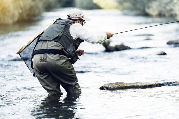 Fly fisherman using flyfishing rod.