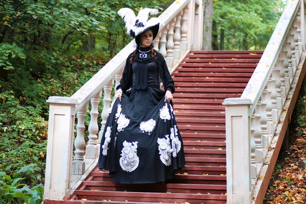 Girl in old retro dress on stairs outdoor