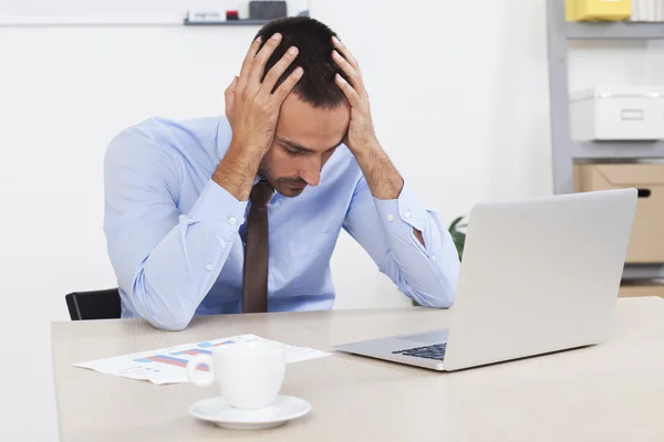 Stressed businessman working at his desk in his office