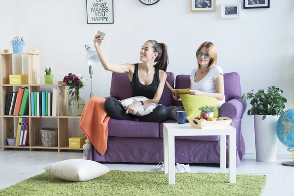 Female friends taking a selfie in the living room