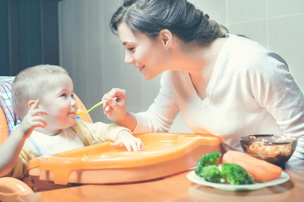 Mom feeds the baby soup. Healthy and natural baby food
