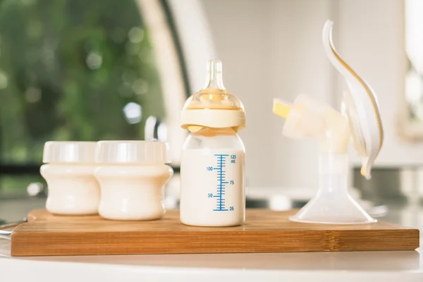 Baby bottle with milk and manual breast pump