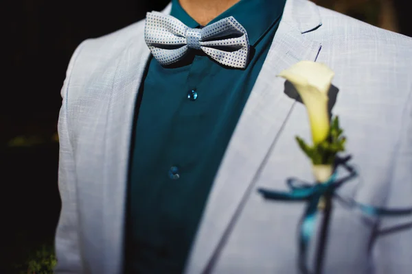 Fiance wearing blue t-shirt and jacket with a lily