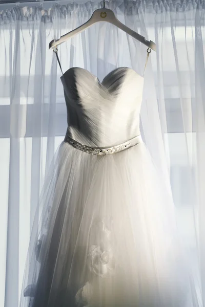 Wedding dress on the hanger before the window