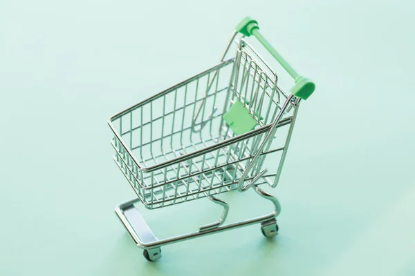 Empty shopping cart over the green background