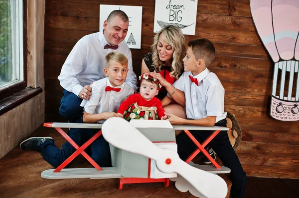 Caucasian family posed in vintage studio room background wooden