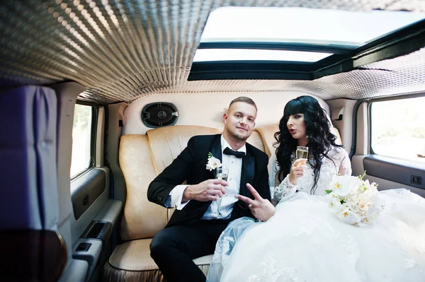 Amazing wedding couple inside elegance limousine at their awesom
