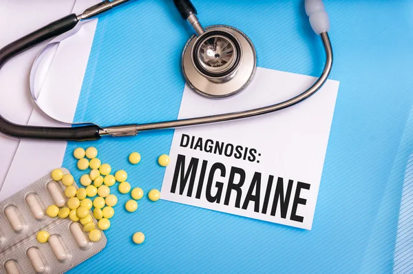 Migraine word written on medical blue folder with patient files