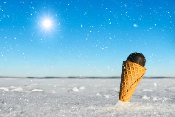 Ice cream cone in the snow. Close up view.