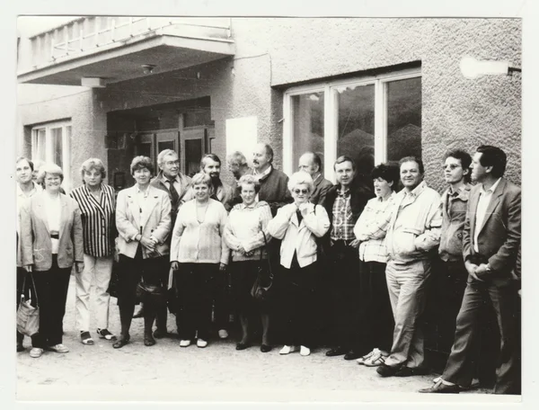 Vintage photo shows a group of  people poses outdoors. Retro black & white  photography